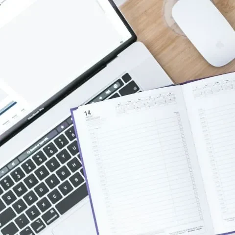 Ordinateur et agenda ouverts, illustrant la gestion et l'organisation des appels d’offres pour le secteur du BTP avec Cap Calade
