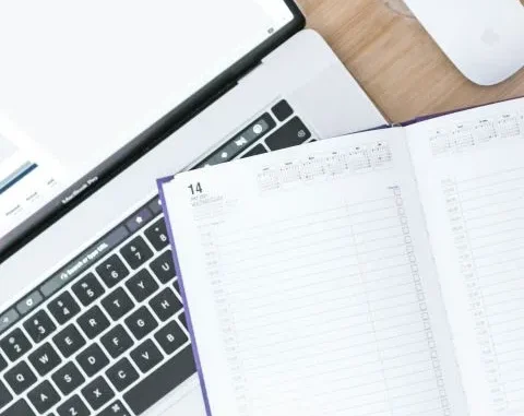 Ordinateur et agenda ouverts, illustrant la gestion et l'organisation des appels d’offres pour le secteur du BTP avec Cap Calade